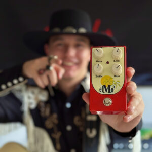 Guitarist Can Bayoglu holding his red RFO Electronics elMo’ overdrive pedal